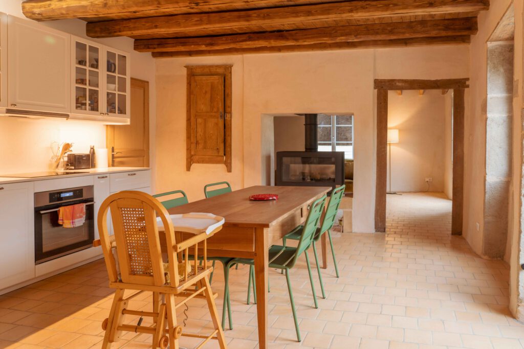 Photographie de la rénovation d'une maison dans le Beaujolais. On y voit une cuisine dans des teintes douces avec des enduits à la chaux sur les murs.