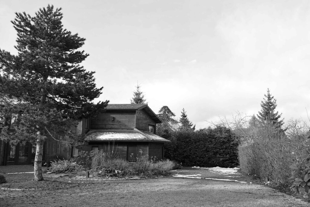 Photographie en noir et blanc d'une maison avant la construction d'un carport en bois dans la Loire.