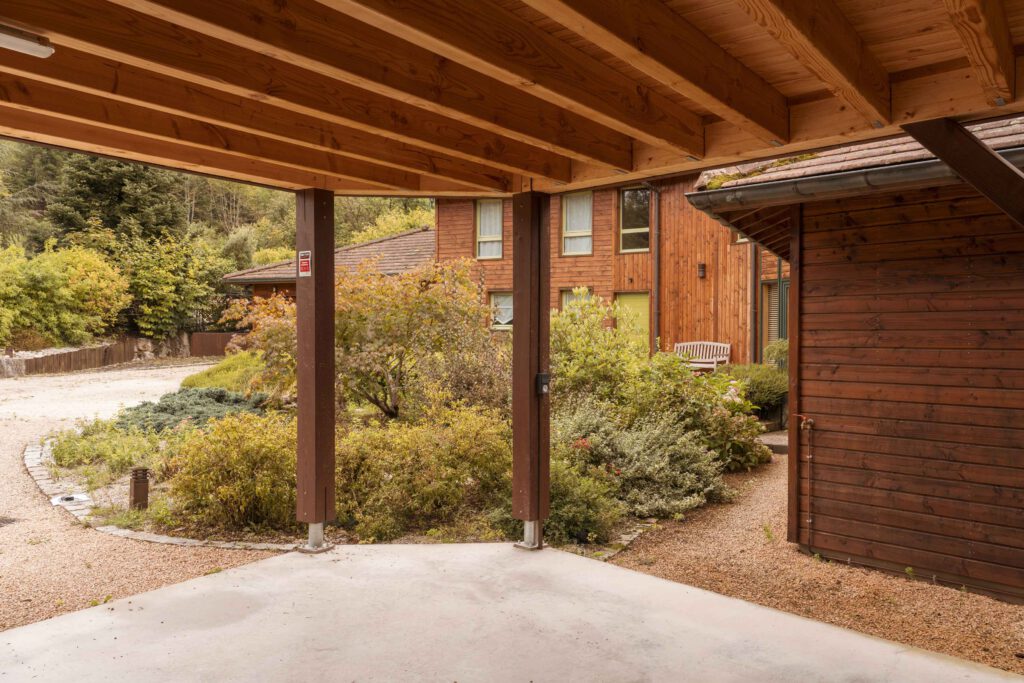 Photographie de l'intérieur d'un carport en bois construit dans la Loire par Ocre architecture.