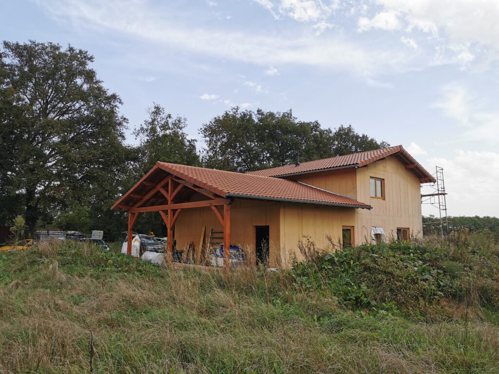 Photographie de l'extérieur d'une maison construite en paille pour un agriculteur de l'Ain.