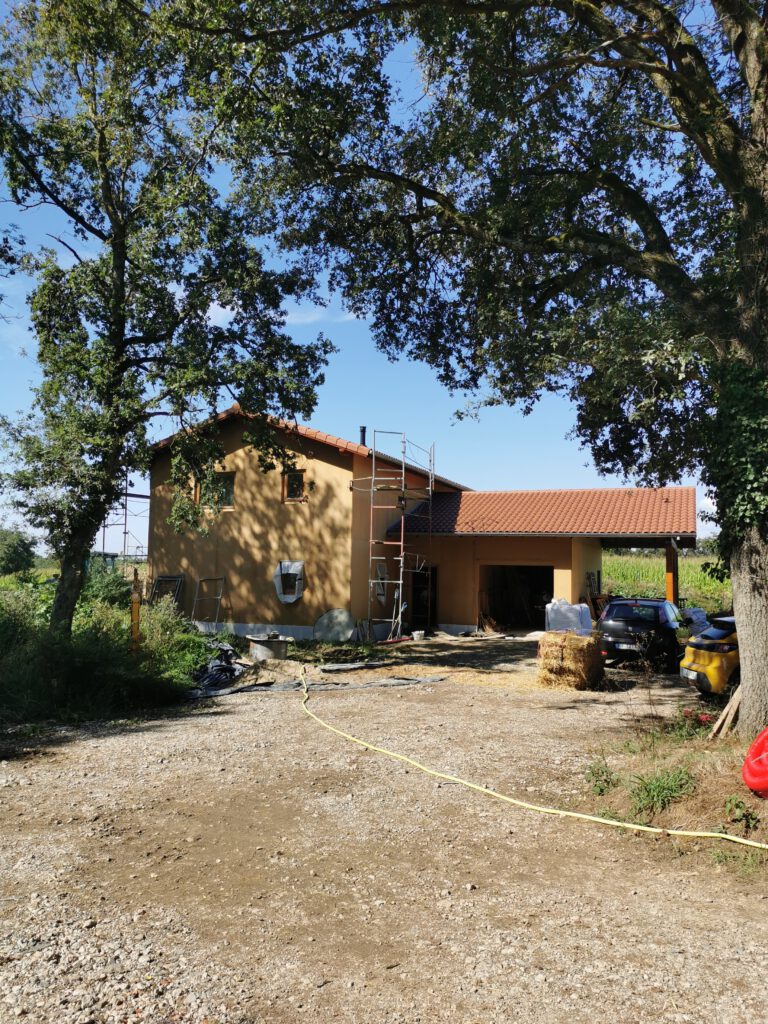 Photographie de l'extérieur d'une maison construite en paille pour un agriculteur de l'Ain.